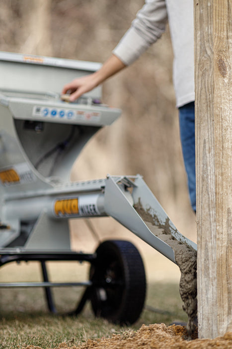 MudMixer Evolution with Chute Extension pouring concrete at a fence post
