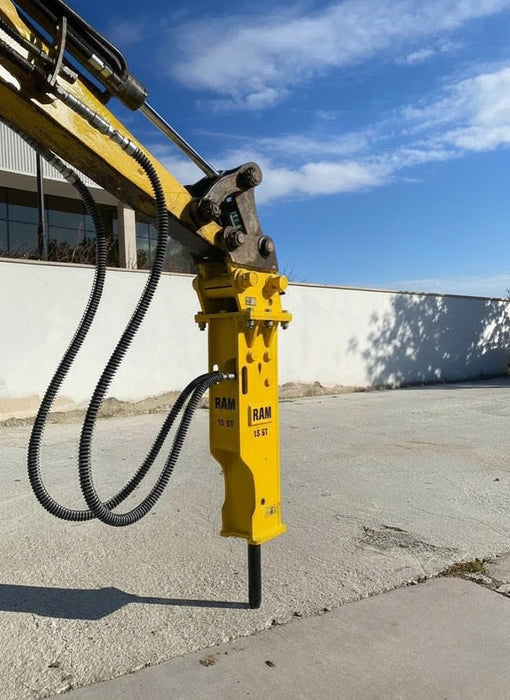 RAMEX RAM hydraulic breaker on an excavator beside a building, representative photo