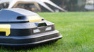 AI-powered robotic mower navigating uneven terrain outdoors