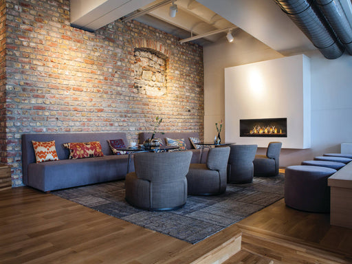 Napoleon Luxuria 50 single-sided natural gas linear fireplace in a lounge with nickel sticks media