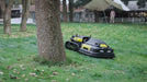 Yarbo mower navigating around garden obstacles in a backyard