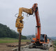 RAMEX auto-tilting vibro hammer driving a pile on an orange excavator