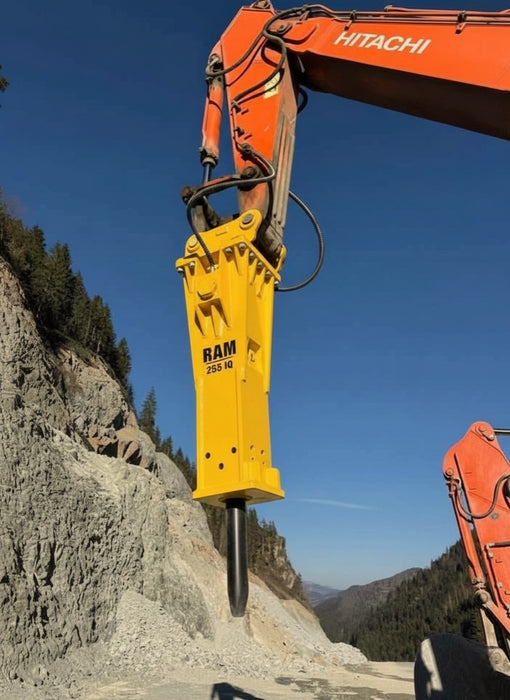 RAMEX RAM hydraulic breaker on an orange excavator on a hillside, representative photo