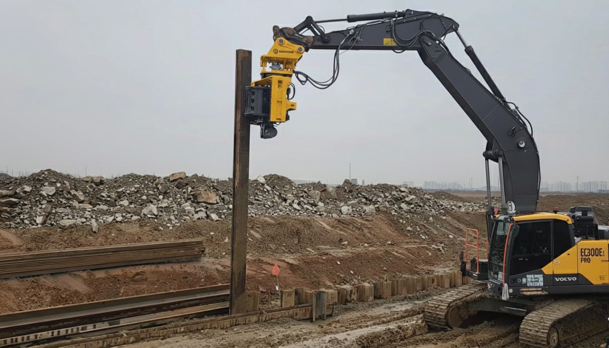 RAMEX side-grip vibro hammer driving a vertical pile, side view