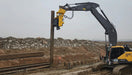 RAMEX side-grip vibro hammer driving a vertical pile, side view