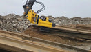 RAMEX side-grip vibro hammer picking up a sheet pile from a stack on site